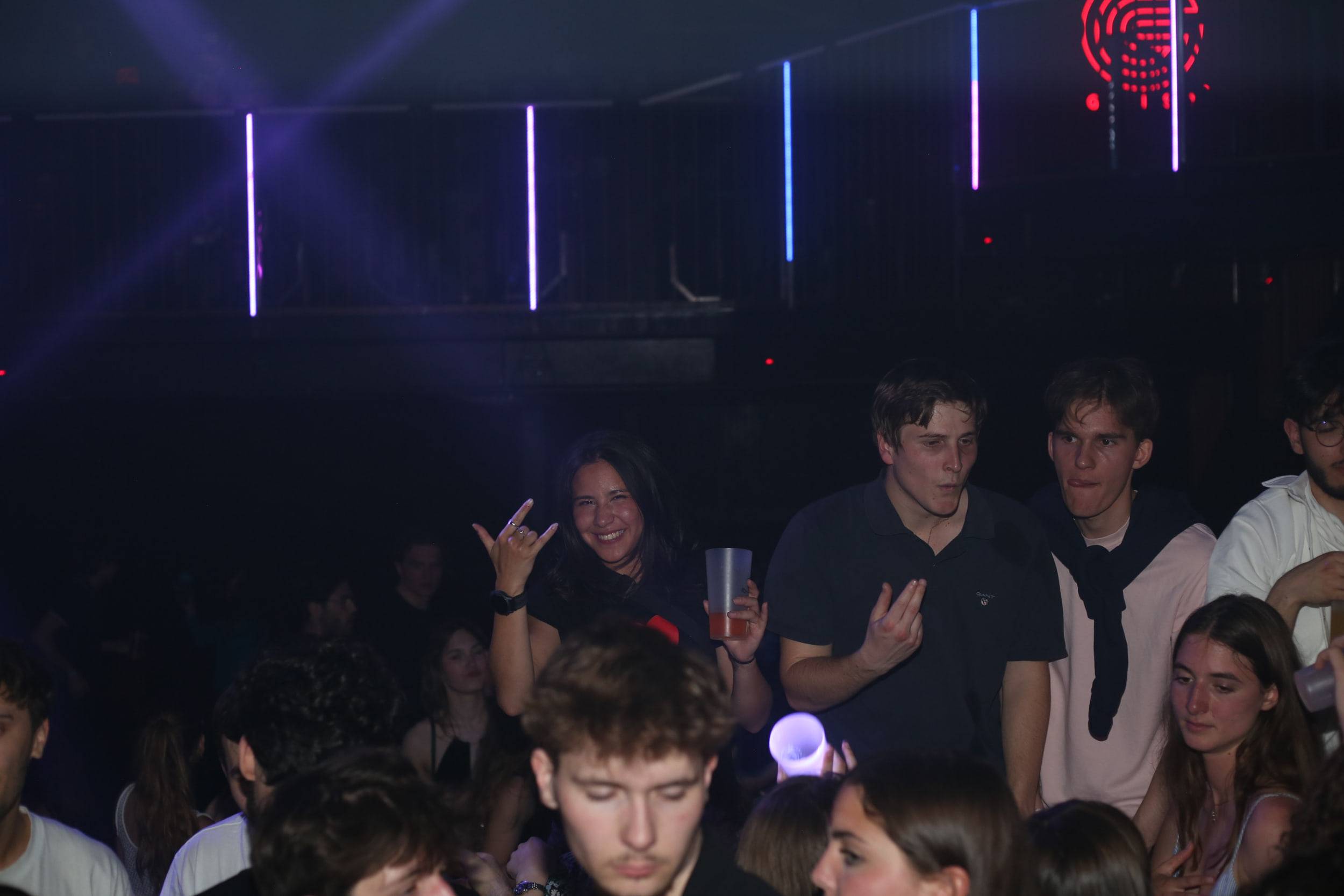 Quelques danseurs sous les néons verticaux du club, un ballon lumineux passe au milieu d'eux.