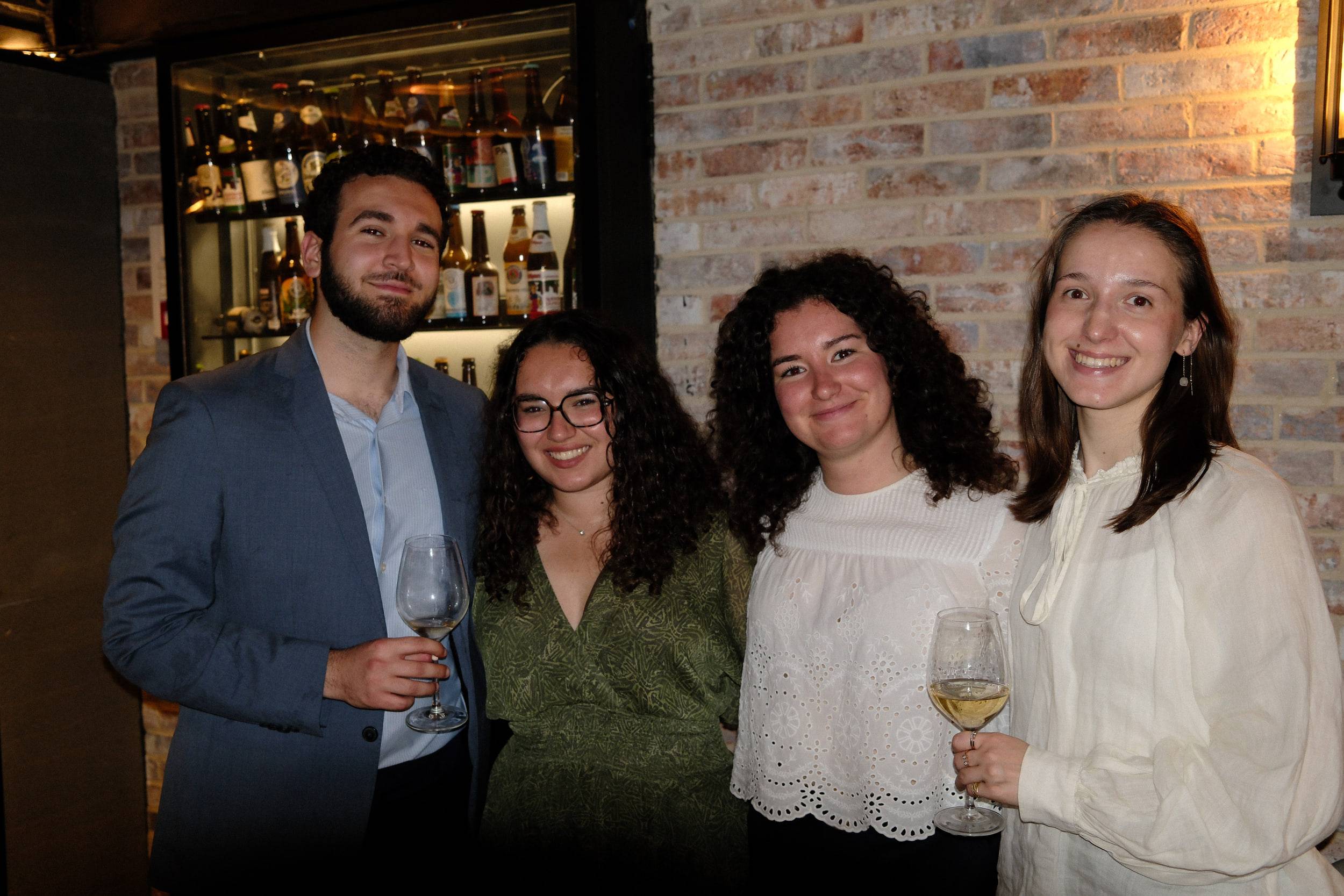 Les mêmes quatre étudiants, cette fois tous tournés vers l'objectif en souriant.
